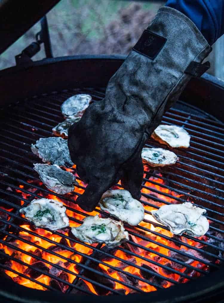 using heat proof gloves to place oysters on the grill