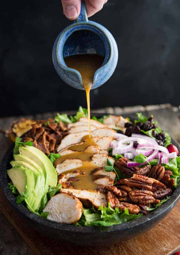 Dressing poured over a grilled chicken salad recipe