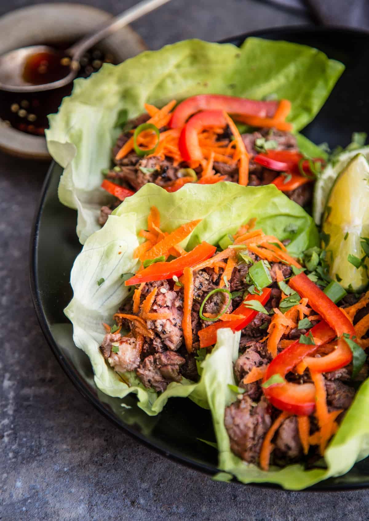 Steak Lettuce Wraps on a plate topped with veggies