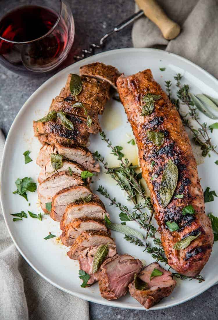 Grilled Pork Tenderloin on a platter topped with fried sage butter