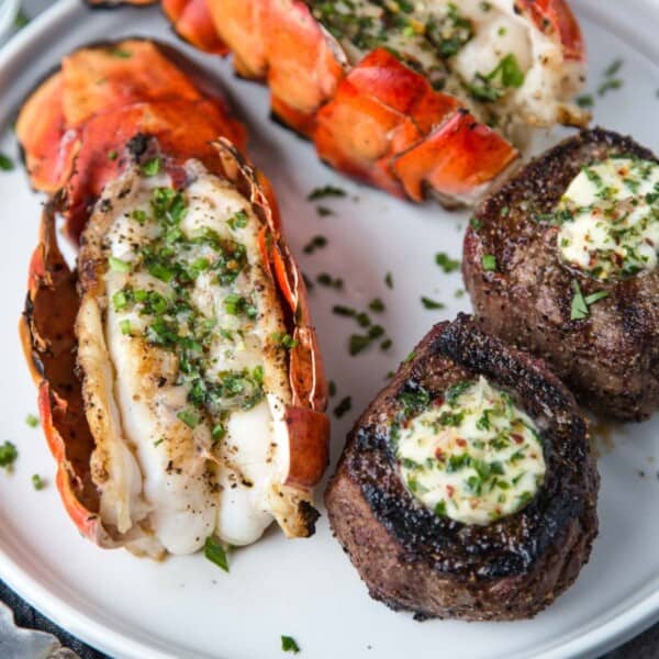 Surf and turf on a plate with grilled lobster tails and grilled petite filet.