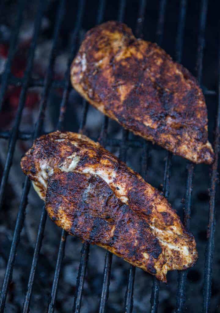 Two chicken breasts cooking on the grill.