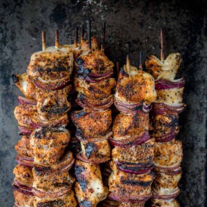 Chicken kabobs on wooden skewers after being marinated.