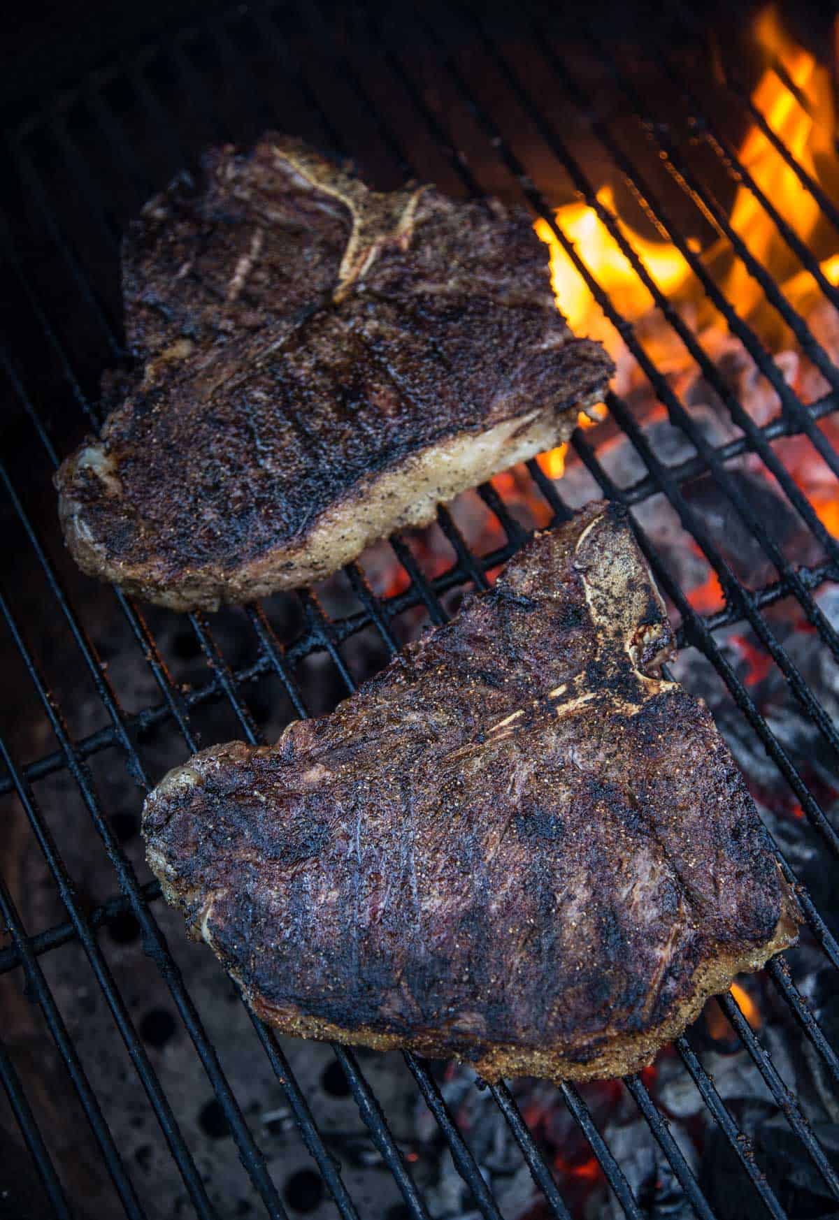 Two Steaks on the grill over a flame