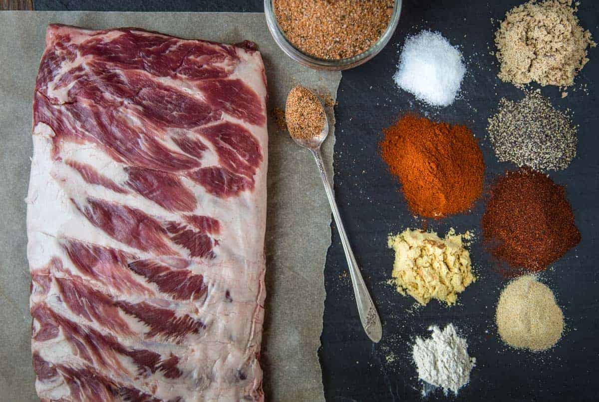 Ingredients for Dry Rub for Ribs on a platter with raw pork ribs