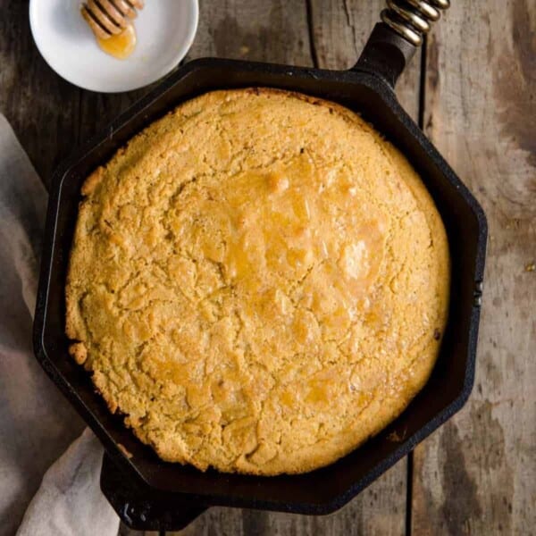 Skillet Corn Bread with smoked honey on table.