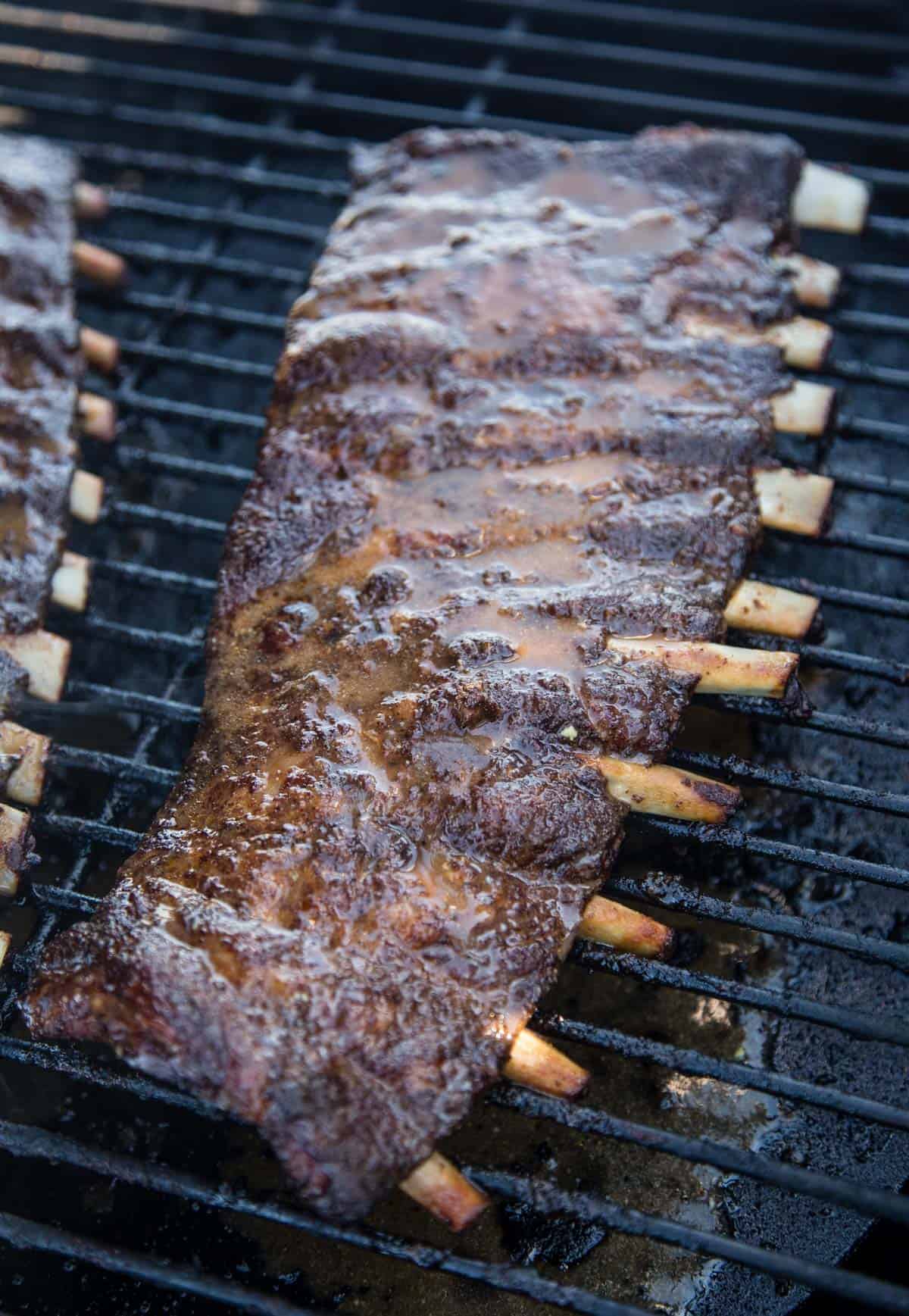 Spare ribs on the smoker mopped with a vinegar sauce