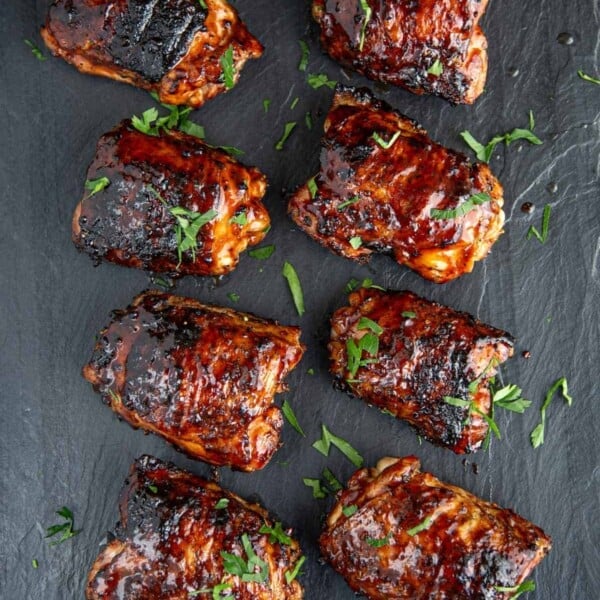 8 Grilled Chicken Thighs on a black platter