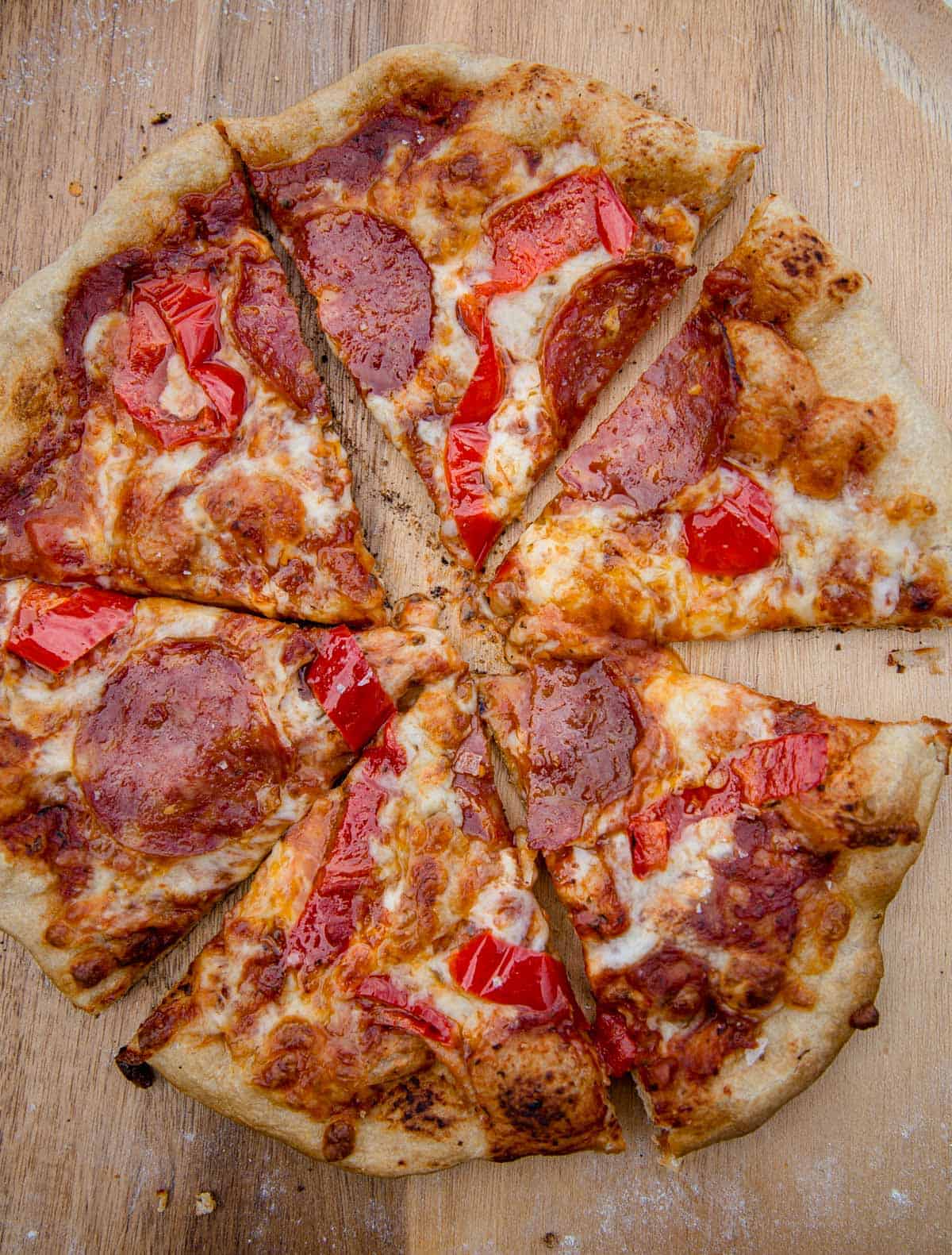 A grilled pepperoni and hot pepper pizza, cut into 6 slices