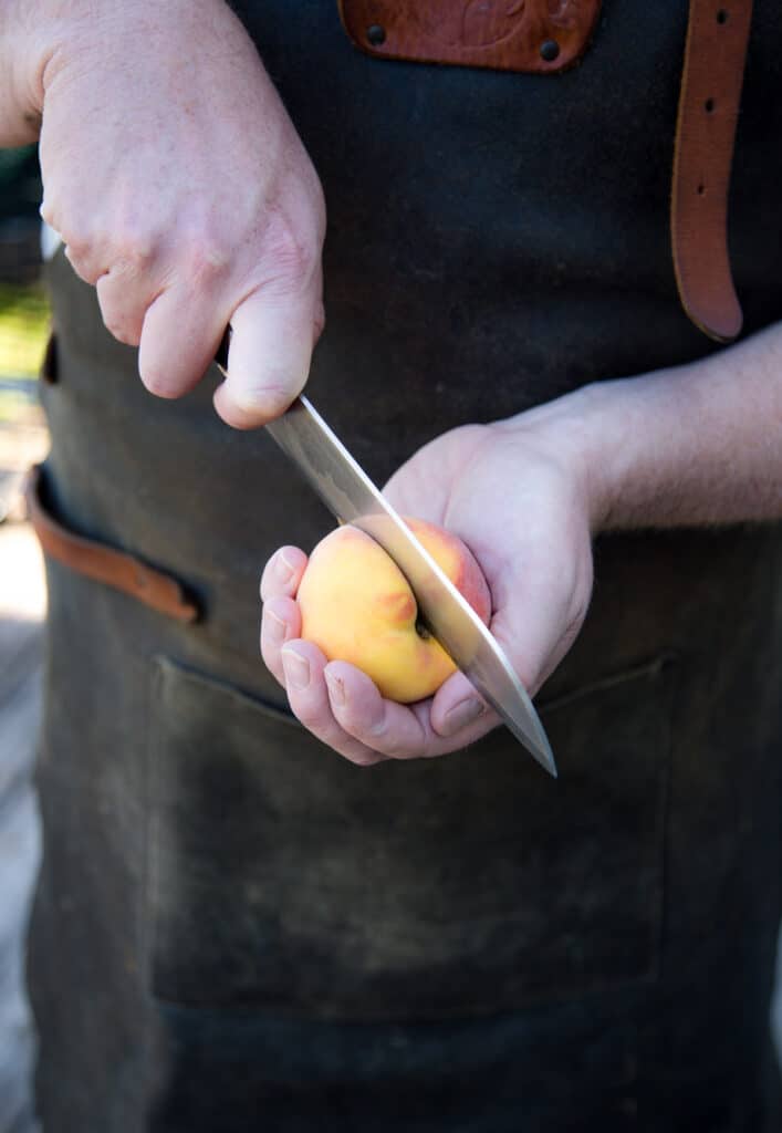 Slicing a peach and removing the pit.