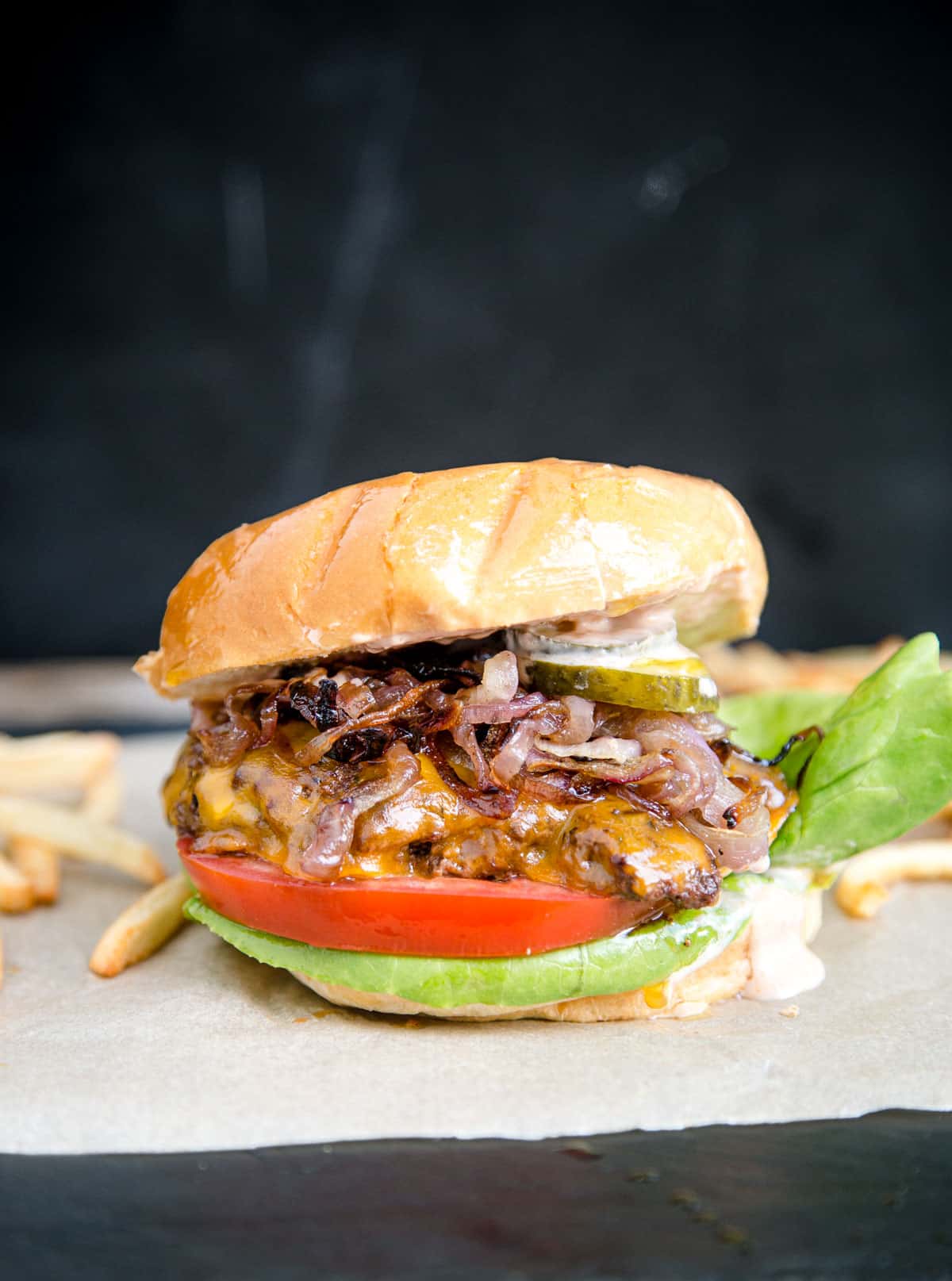 A grilled smash burger with caramelized onions