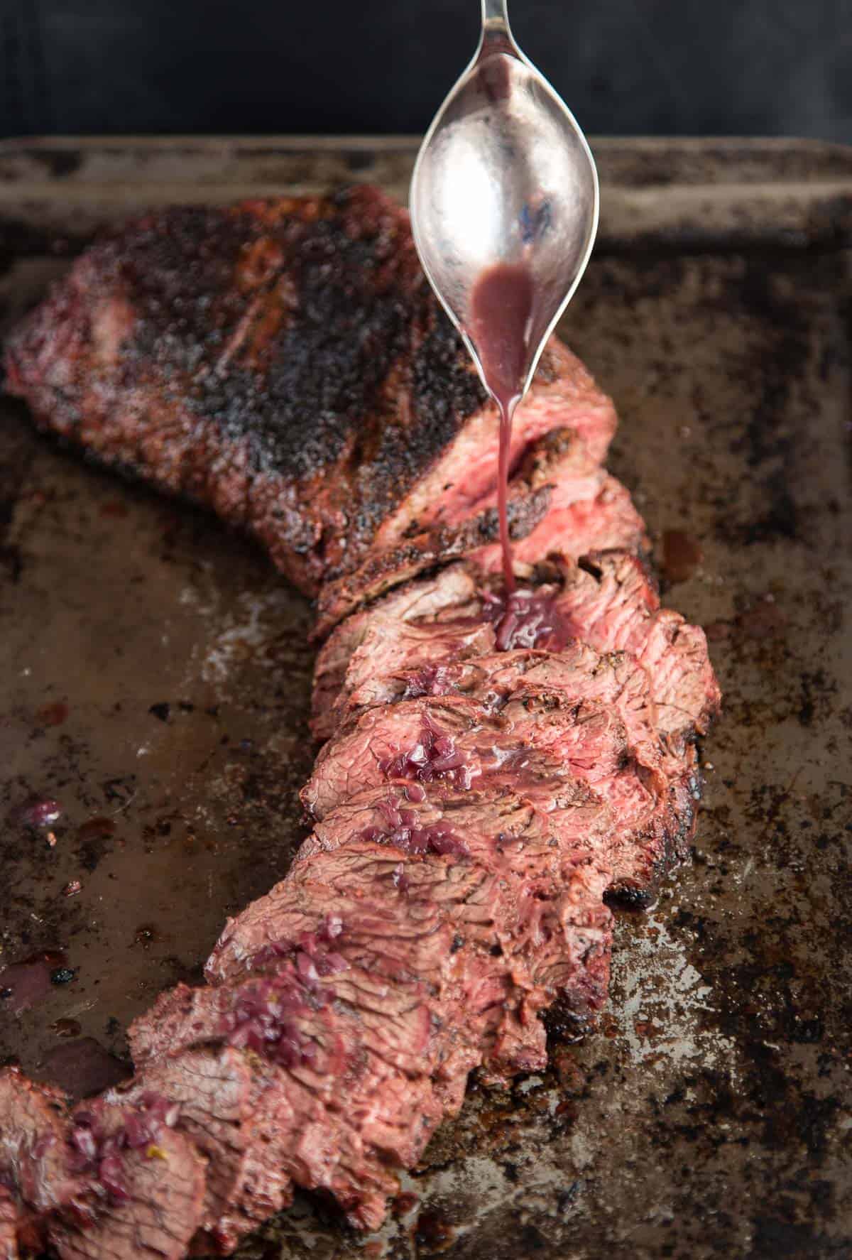 A grilled Tri Tip on a platter with Barbera wine glaze drizzling over the top