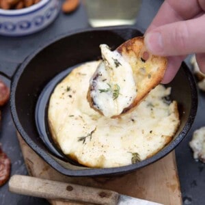 grilled baked brie cheese in cast iron pan with almonds.