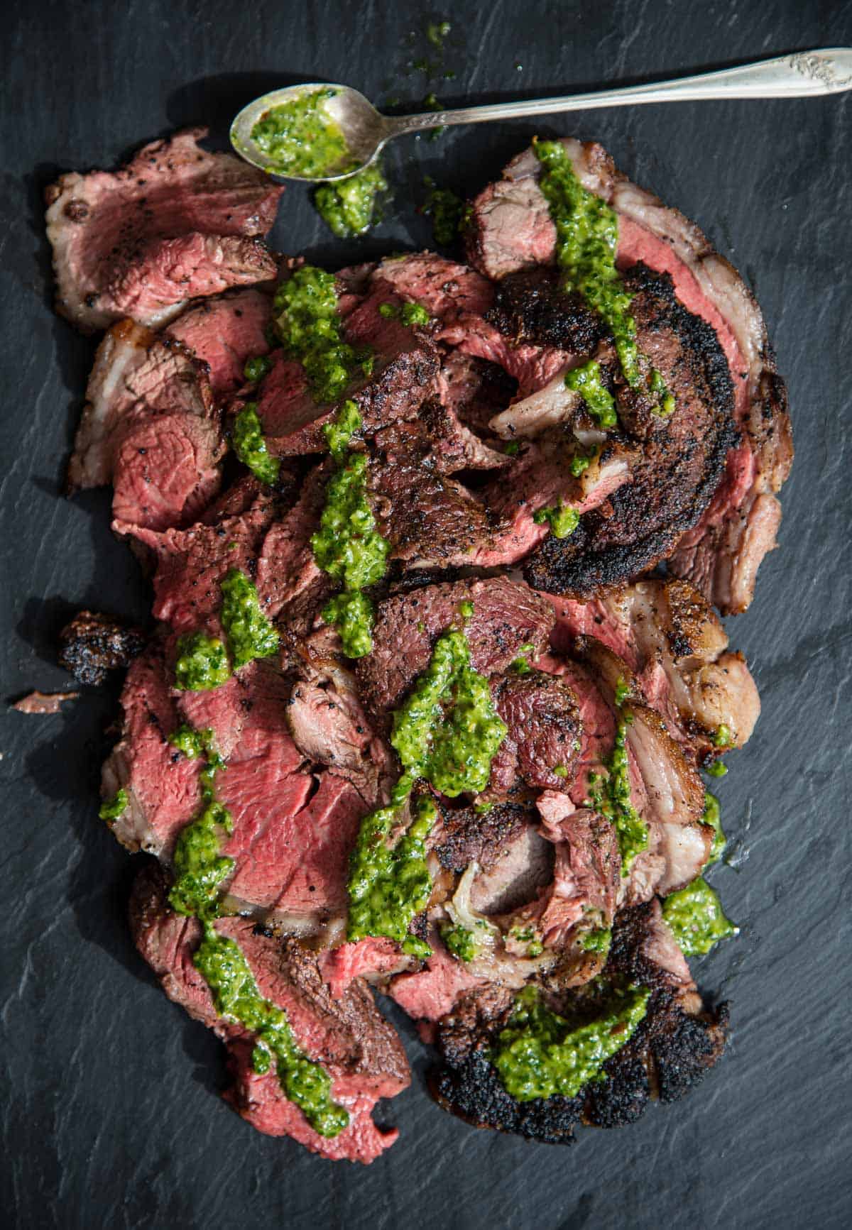 Slices of Grilled Picanha topped with chimichurri sauce.
