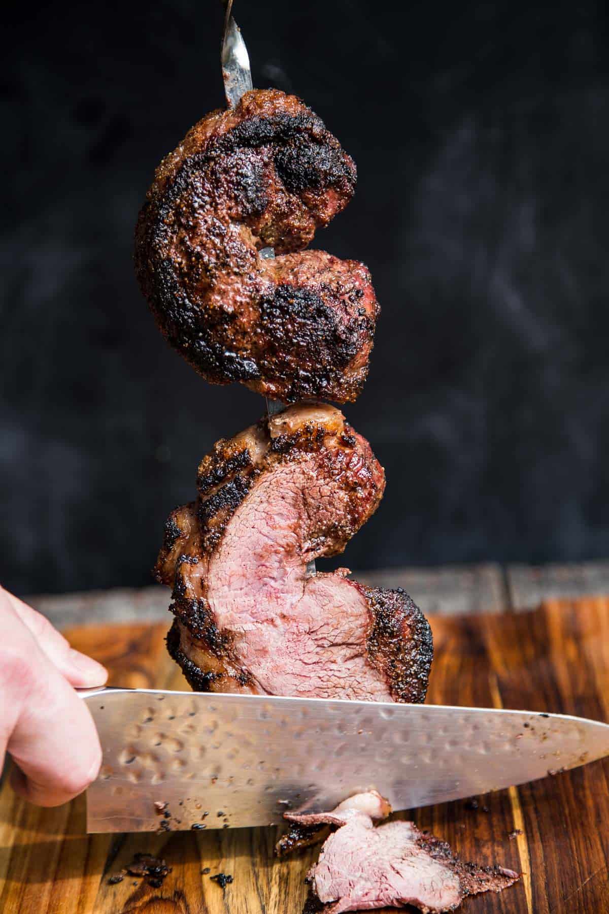 Slicing a Grilled Picanha steak into thin slices.