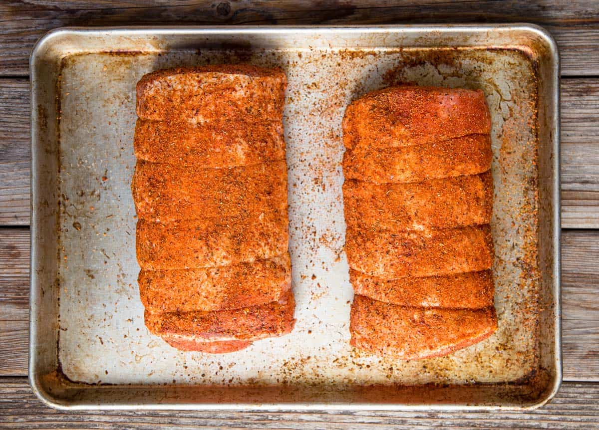 A raw pork loin coated with seasoning