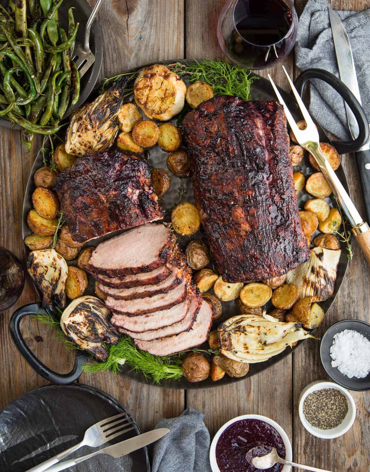Grilled Pork Loin with Blackberry Wine Glaze on a platter with roasted potatoes.