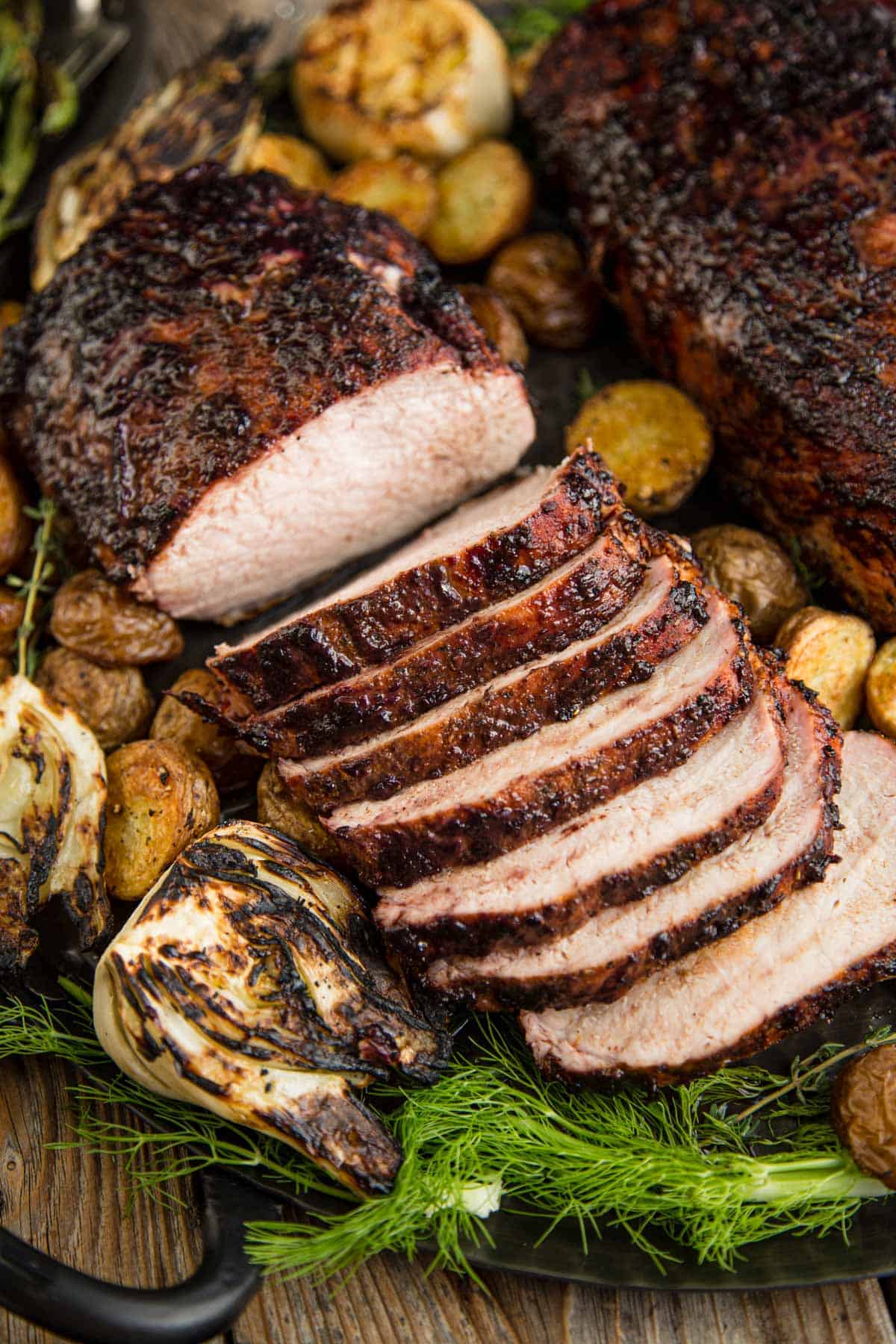 Slices of Grilled Pork Loin on a platter with roasted potatoes