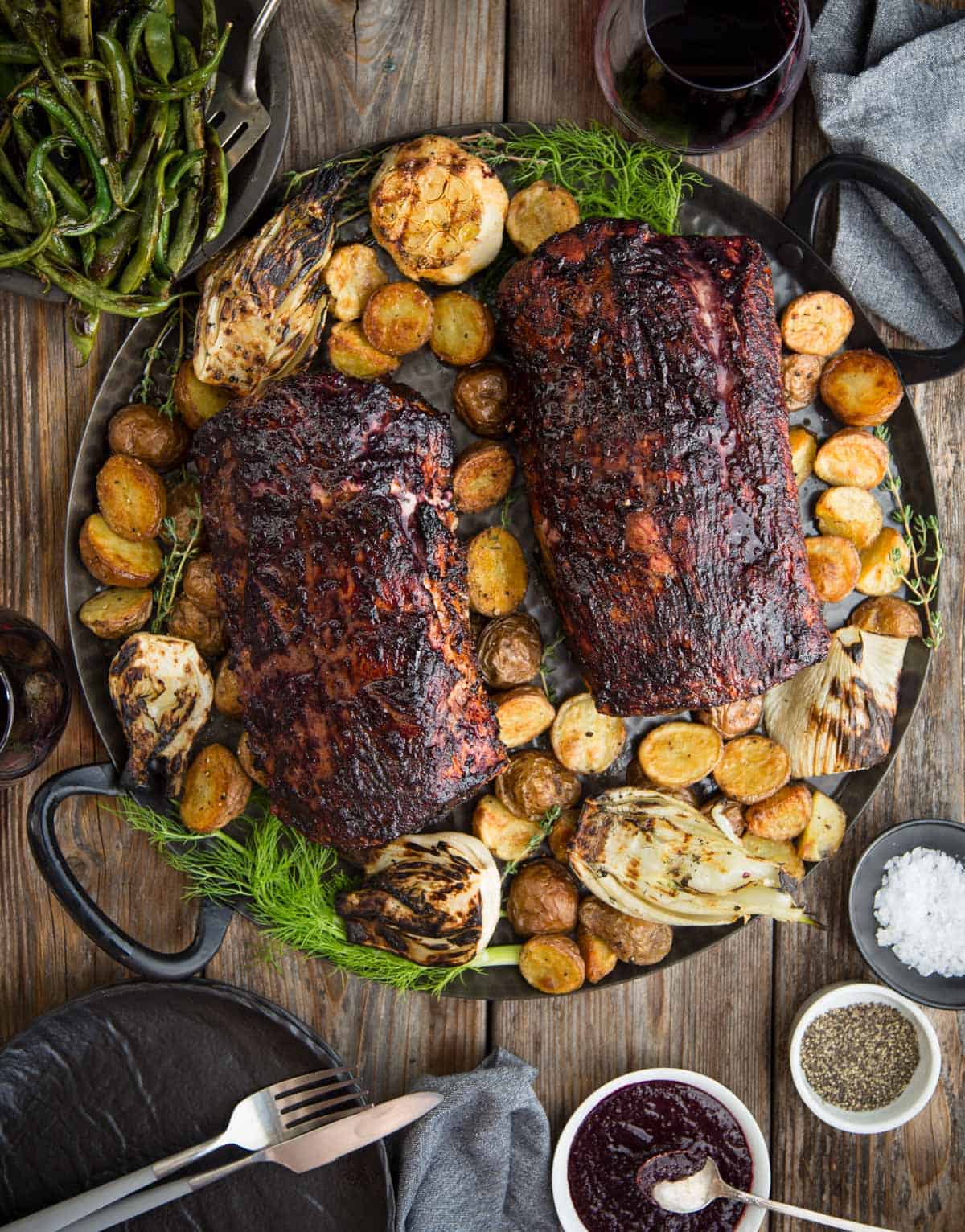 Two Grilled Pork Loins on a platter with roasted vegetables