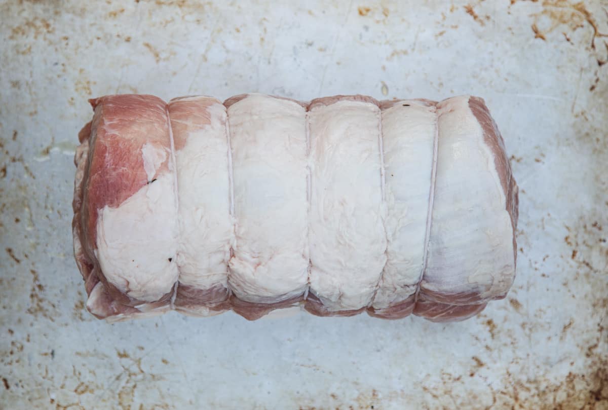 A raw pork loin on a baking sheet