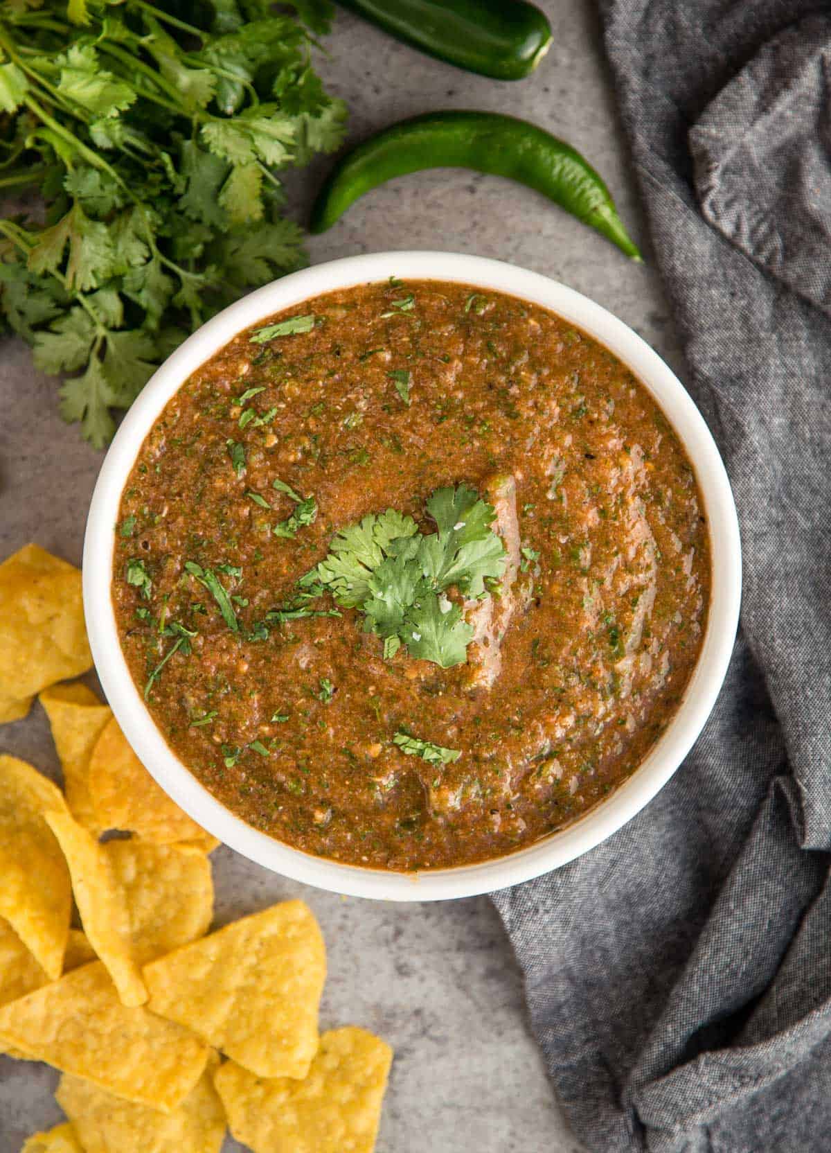 Fire Roasted Salsa in a bowl with some chips and cilantro.