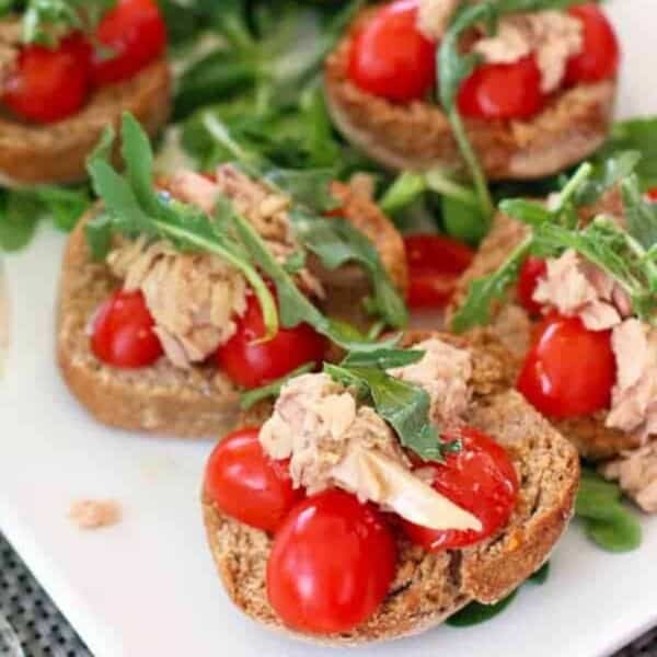 Tuna Toast topped with cherry tomatoes and arugula