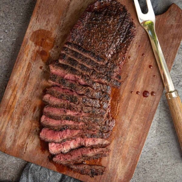 Grilled flat iron steak sliced on a cutting board.