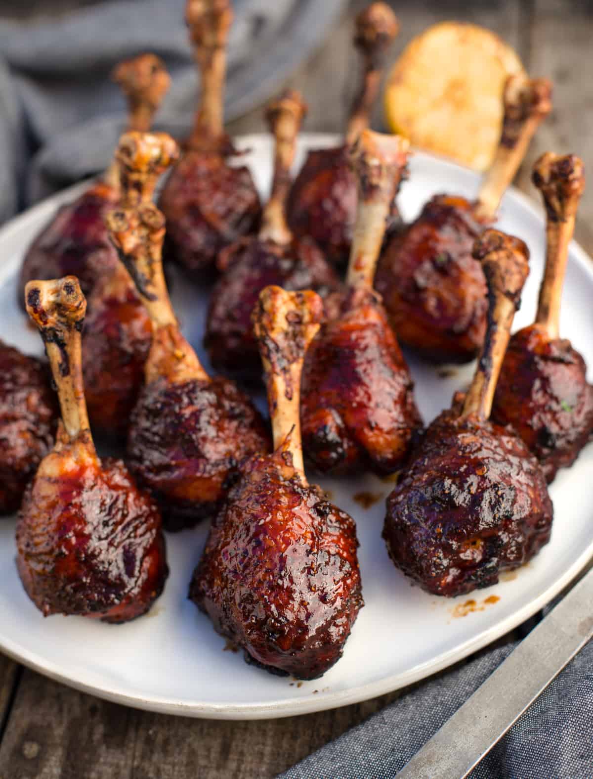 Grilled Chicken Lollipops with BBQ Sauce on a white platter