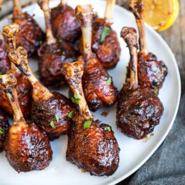 grilled chicken lollipops with sauce glaze on a plate.
