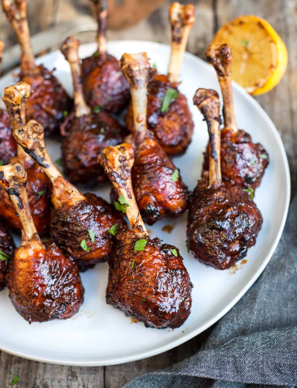 grilled chicken lollipops with sauce glaze on a plate.