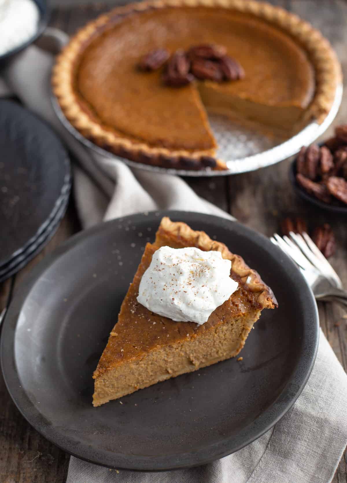 A slice of grilled pumpkin pie on a black plate