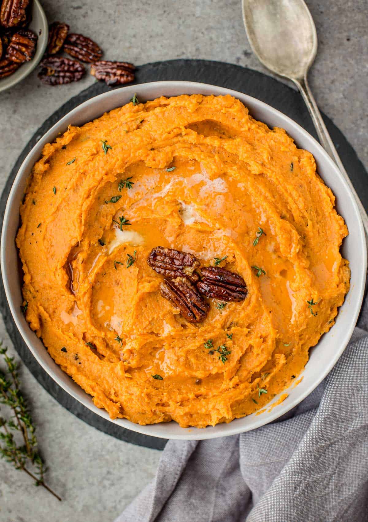 A bowl filled with grilled sweet potato mash topped with candied pecans