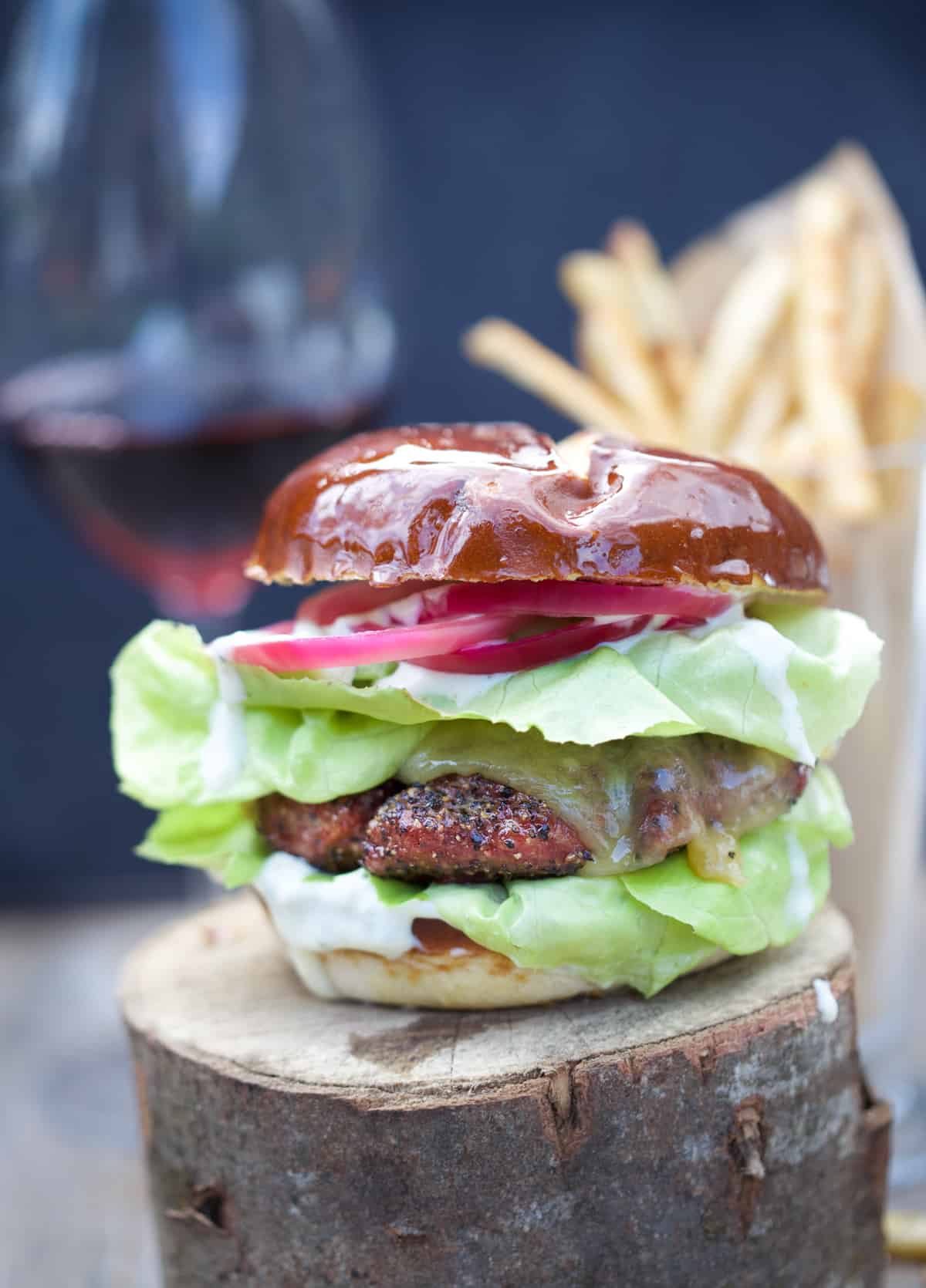 A smoked lamb burger garnished with pickled onions, lettuce and an aioli sauce.