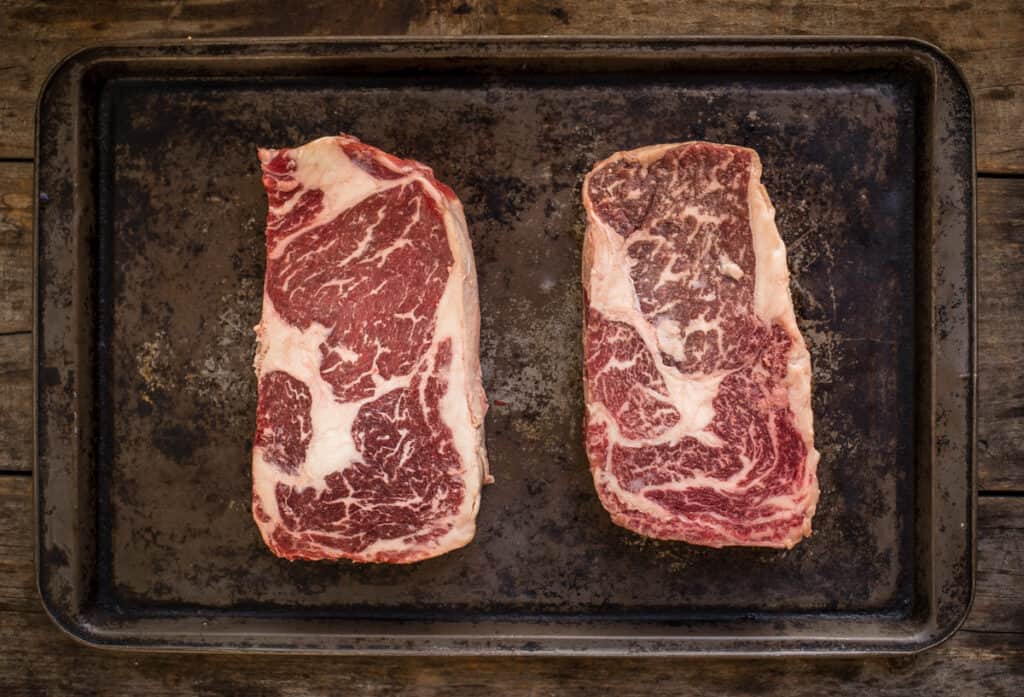 Prime marbled ribeye on the left and American Wagyu on the right and unseasoned.