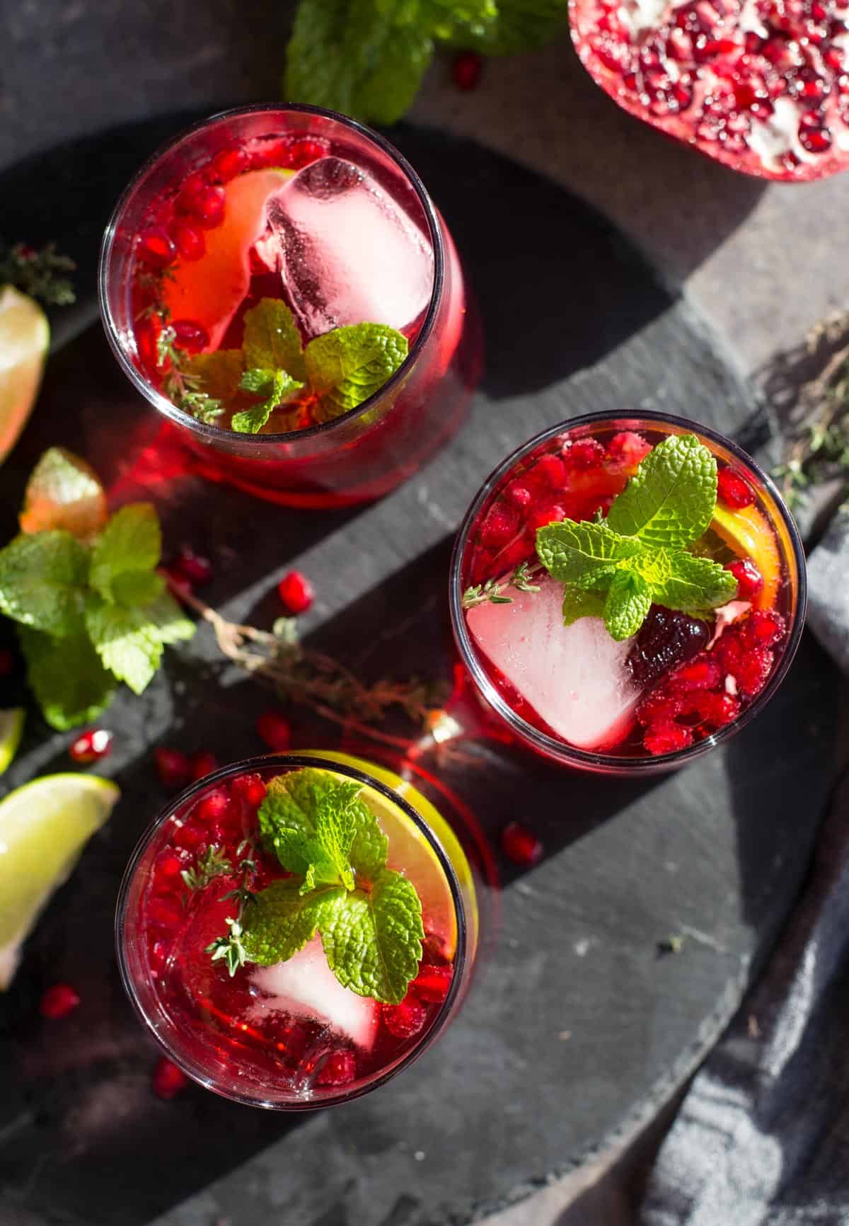 Three festive holiday cocktails on a black slate serving platter