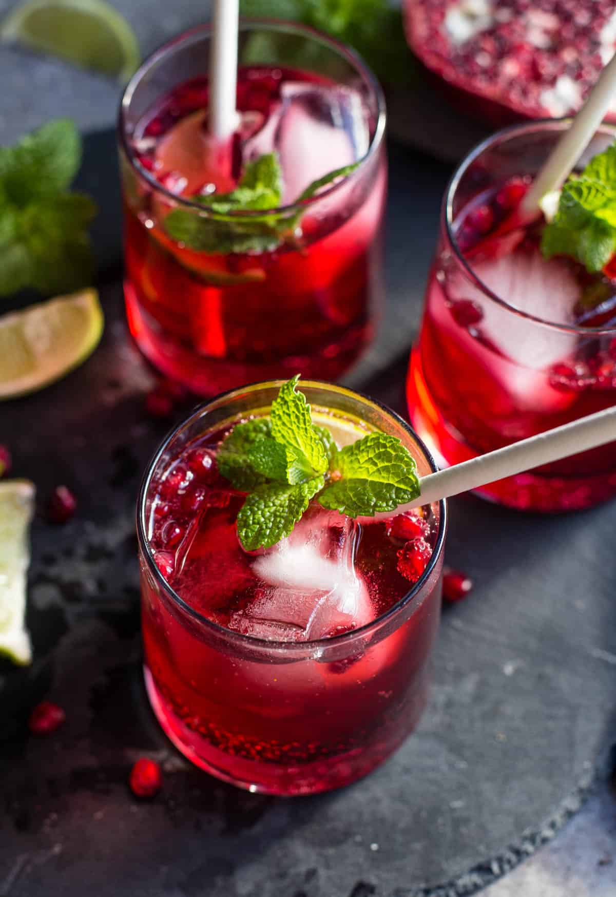 Three ginger pomegranate cocktails on a black slate platter