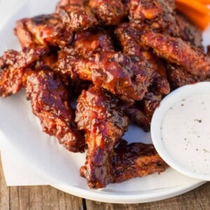 Grilled BBQ wings on a plate with sauce.