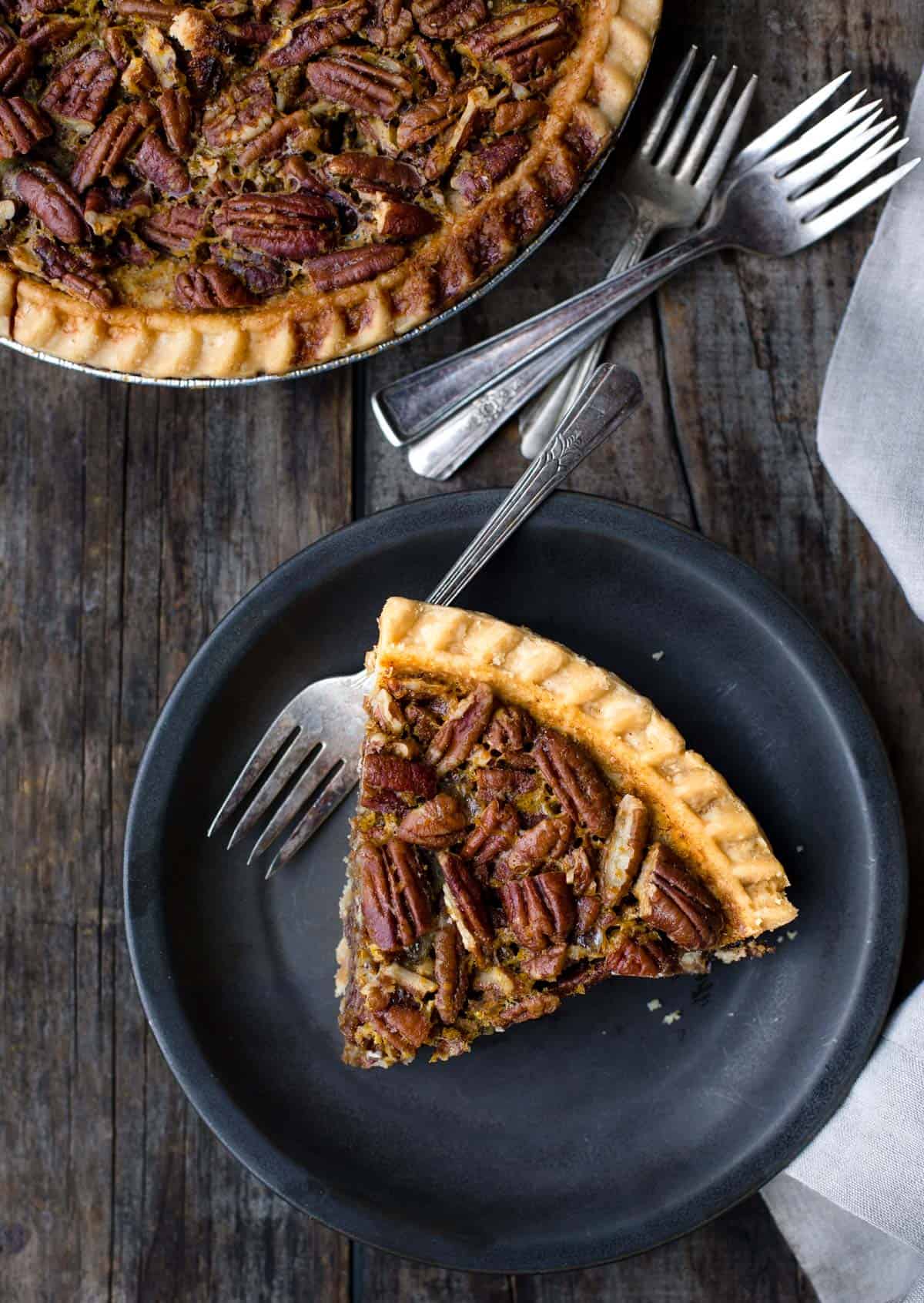 A slice of grilled pecan pie on a black plate