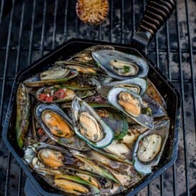 cast iron pan of mussels on the grill