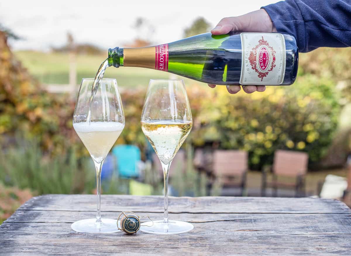 Pouring Champagne into two champagne flutes 