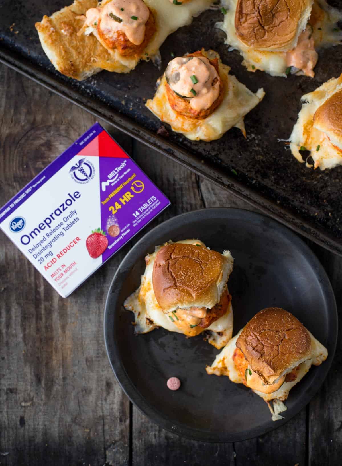 A platter of Buffalo Chicken Meatball Sliders alongside a package of Omeprazole