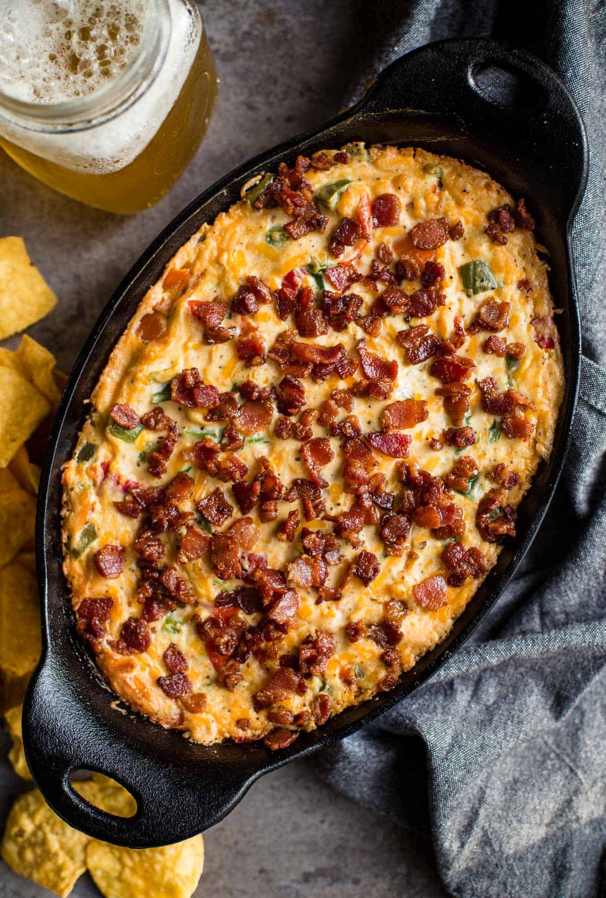 Grilled jalapeño pepper dip with bacon in a cast iron pan.
