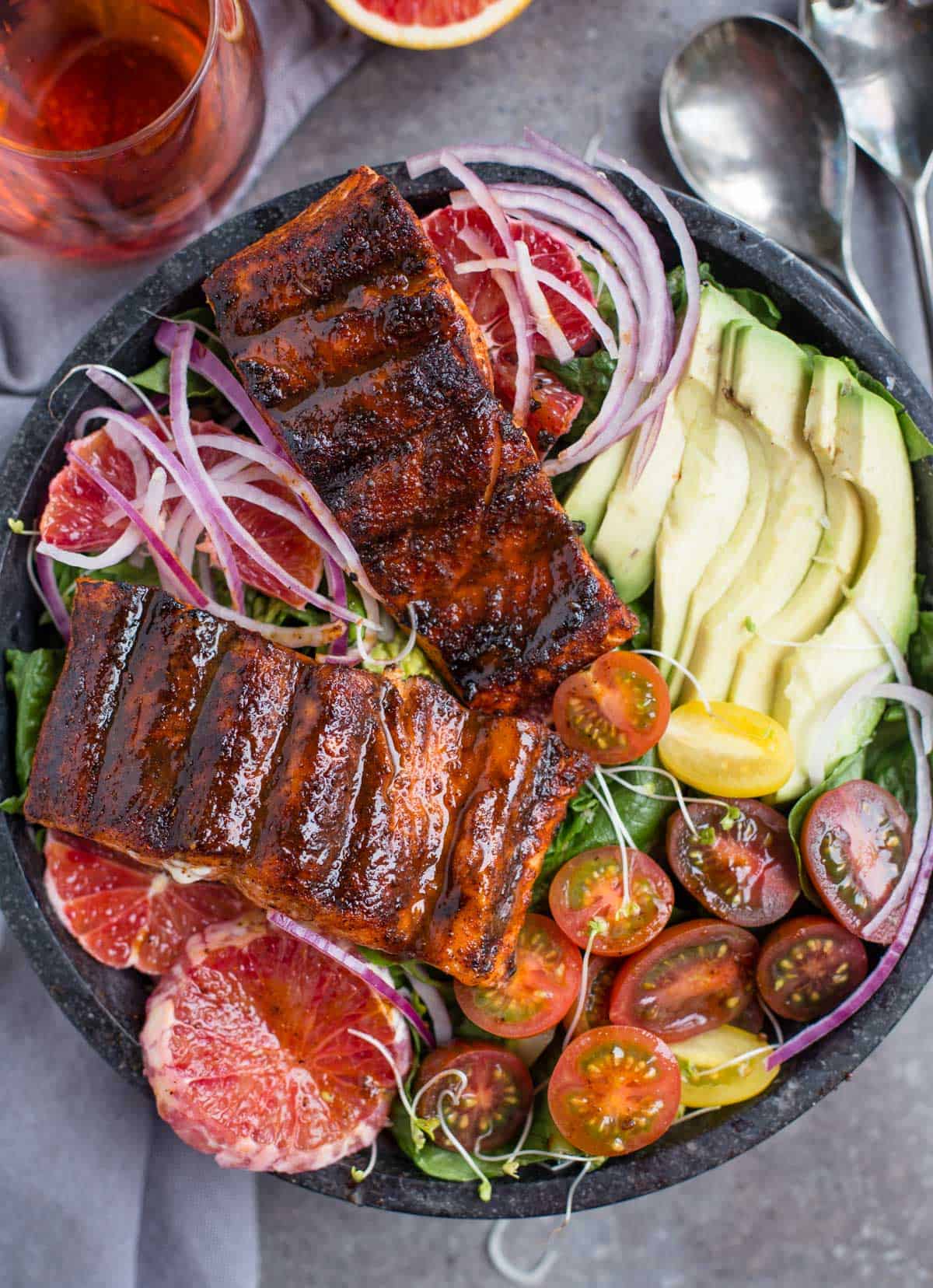 Grilled Salmon salad in a bowl with a glass of rose wine
