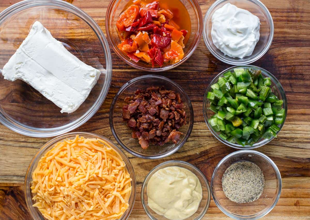 Ingredients for jalapeño popper dip recipe on a cutting board