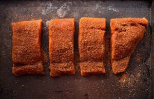 seasoned salmon steaks cut up before grilling