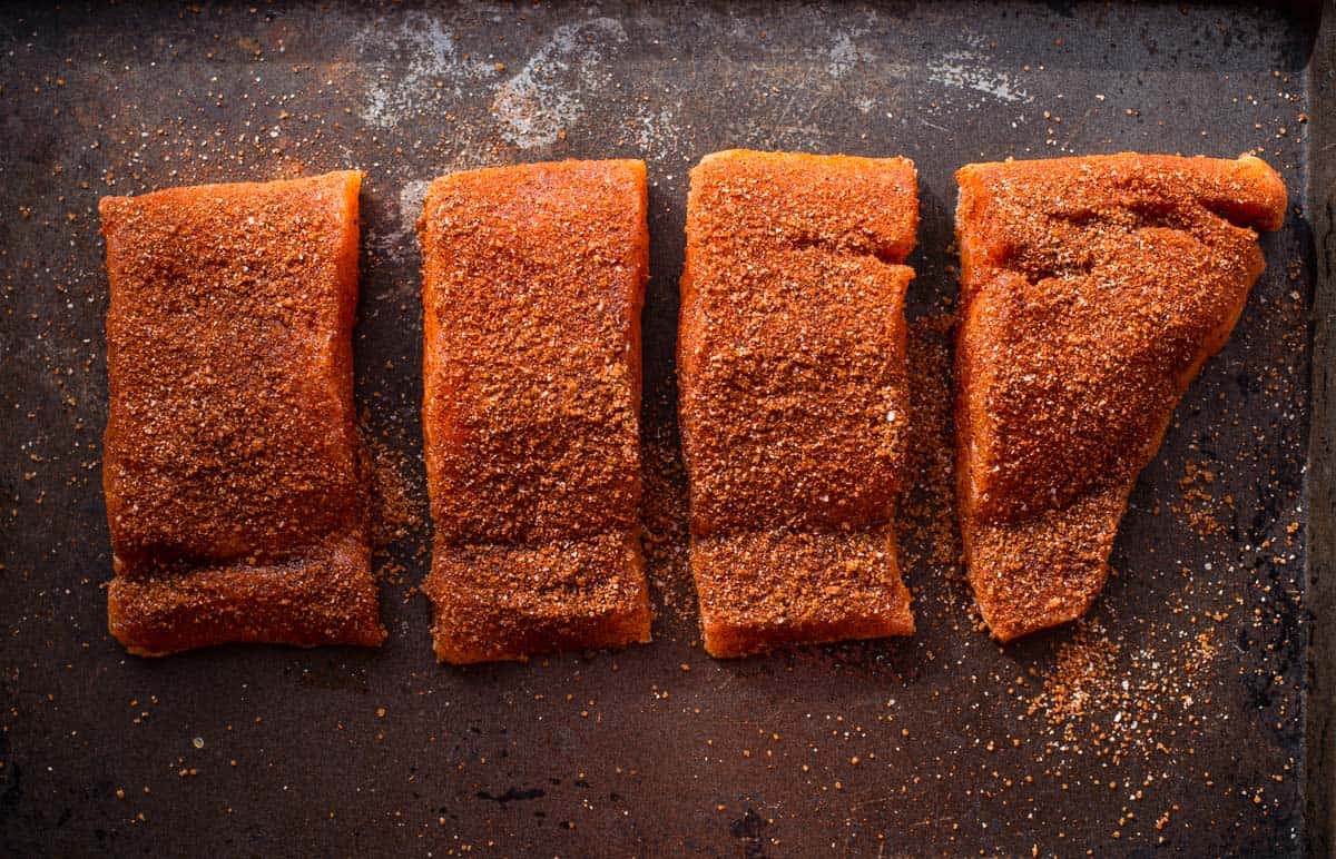 Raw salmon cut into pieces and covered with a blackened seasoning spice 