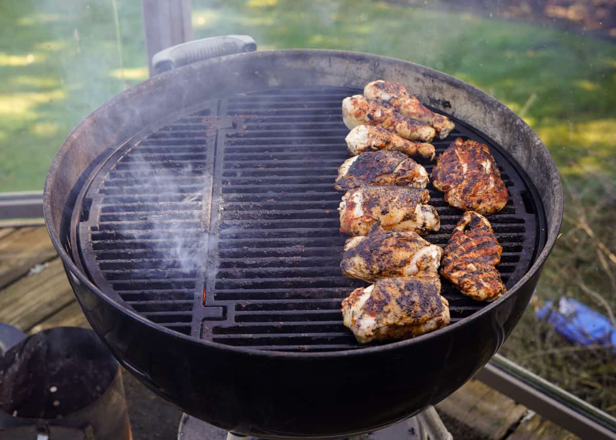 Jerk Chicken cooking on a weber kettle grill using two-zone cooking