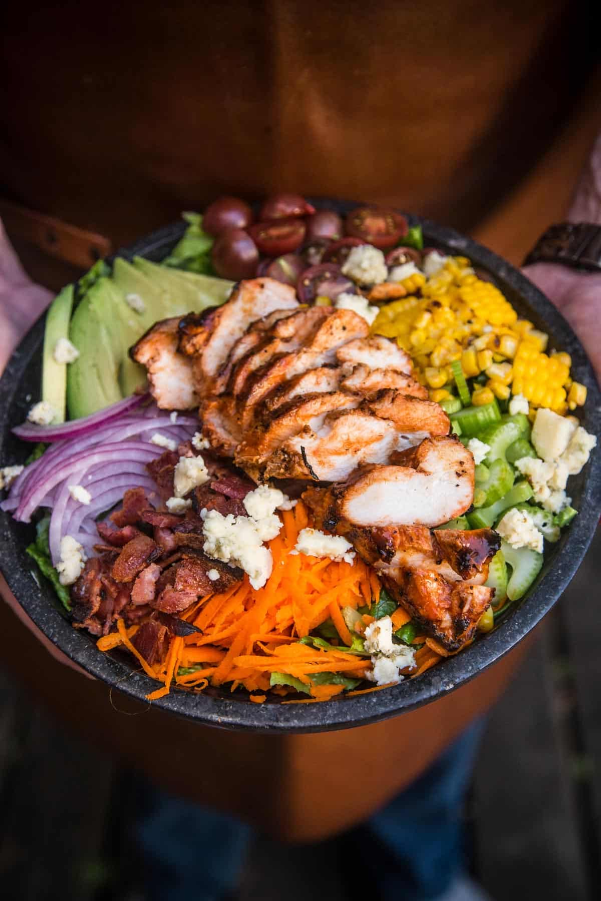 Holding a Grilled Buffalo Chicken Salad in a large bowl