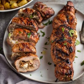 Sliced stuffed pork tenderloin on a plate.