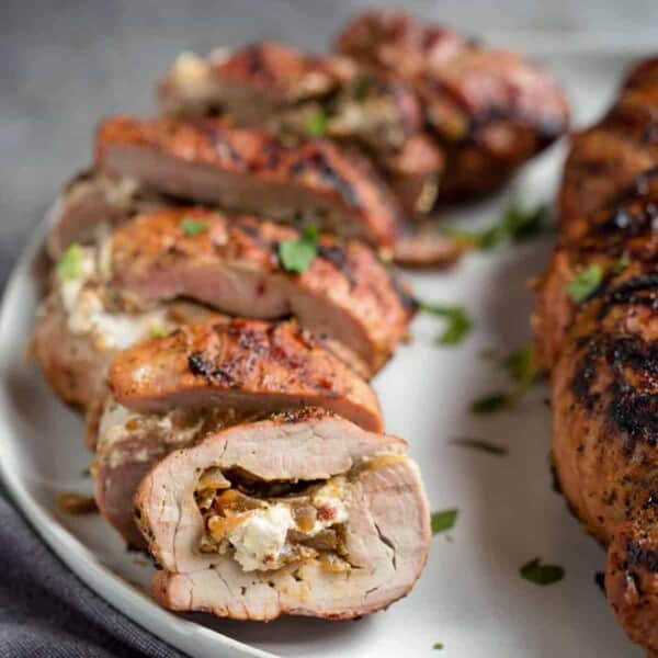 stuffed pork tenderloin sliced on a plate.